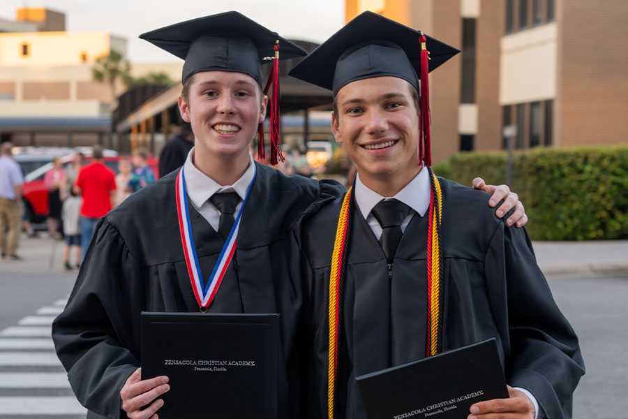 Graduates smiling with diplomas