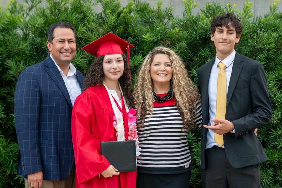 Graduate with family holding diploma