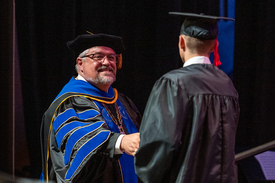 Graduate shaking hands with Dr. Shoemaker