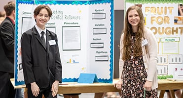 Two students at their STEM Fair displays