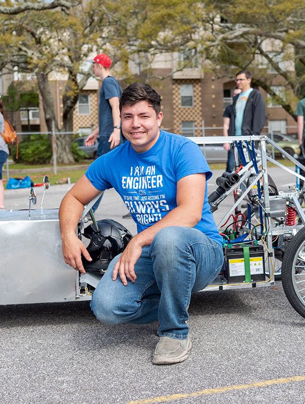 student with custom built electric car