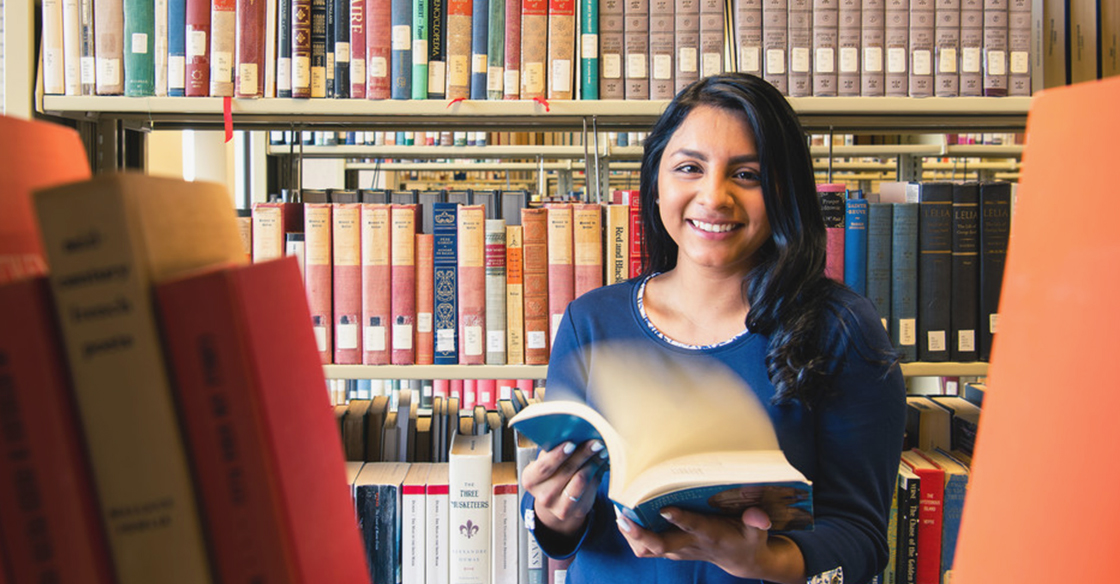 girl in library holding book 