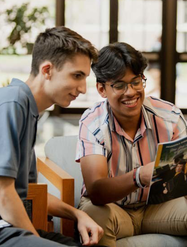 young men looking at college days brochure
