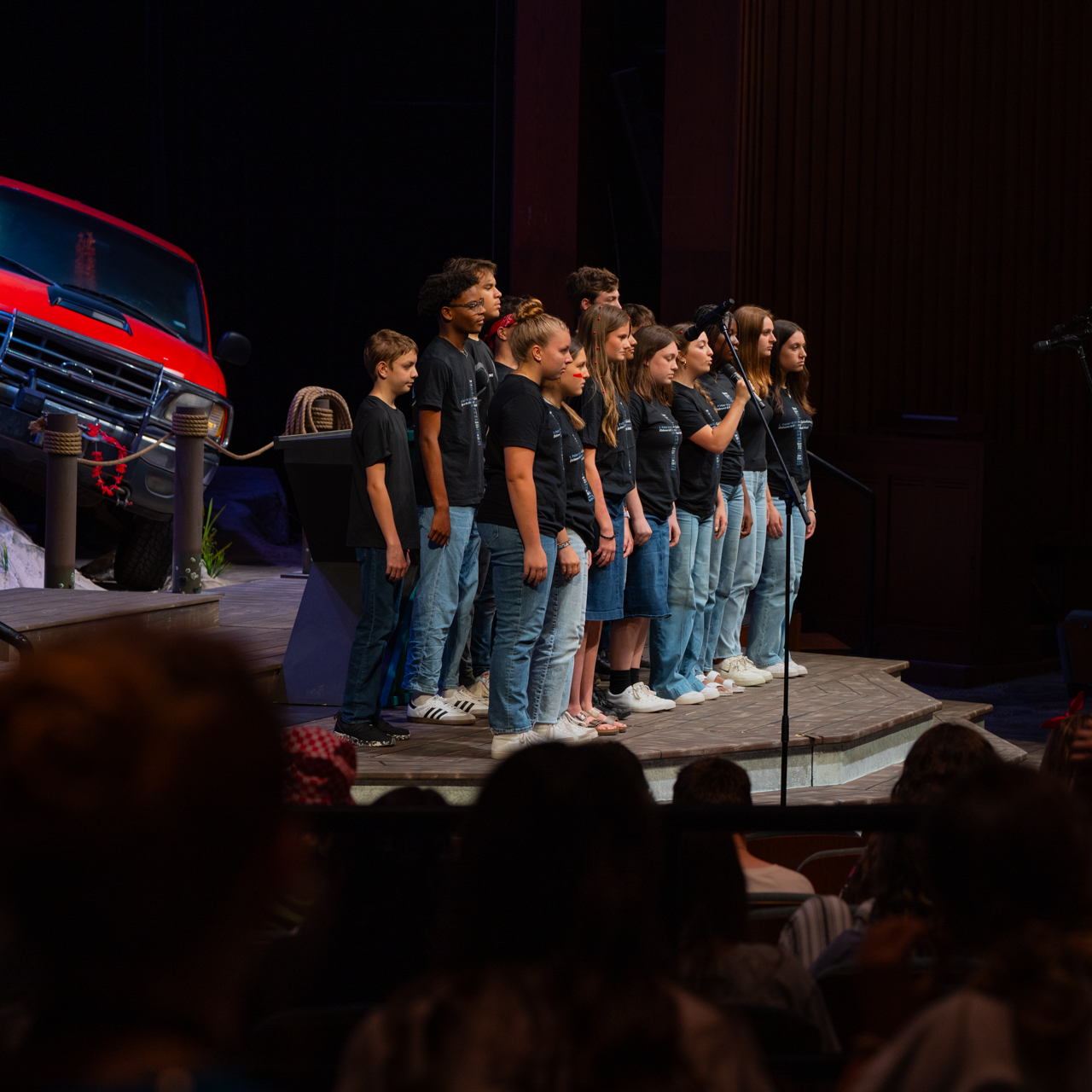 Campers wearing matching shirts and singing